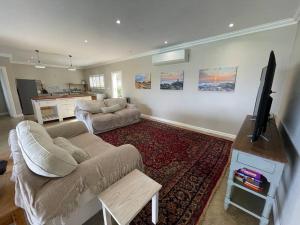 sala de estar con sofá y TV de pantalla plana en Ocean Mist, Port Edward, en Port Edward