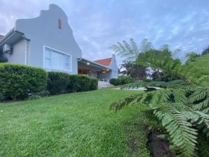 una casa con una palmera frente a un patio en Ocean Mist, Port Edward, en Port Edward