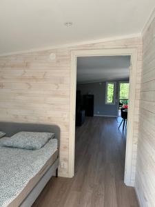 1 dormitorio con 1 cama y pared de madera en Apartment Ormestad en Uddevalla