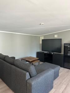 a living room with a couch and a flat screen tv at Apartment Ormestad in Uddevalla