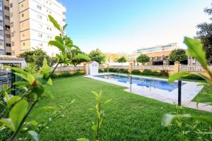 un patio trasero con piscina y césped en Burgos 2 Terrace, pool, parking by 10ToSea en Fuengirola