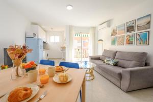 una cocina y una sala de estar con una mesa con comida. en Burgos 2 Terrace, pool, parking by 10ToSea en Fuengirola