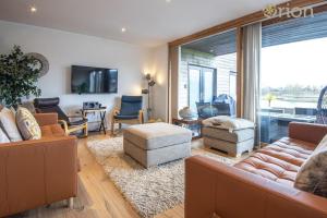 a living room with a couch and a table at Waters Edge 15, Kingsholm P in South Cerney