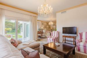 a living room with a couch and a tv at Villa Galemar Pool & Gardens in Torremolinos