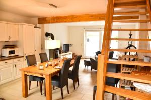 eine Küche und ein Esszimmer mit einem Holztisch und Stühlen in der Unterkunft Ostsee Auszeit in Pruchten