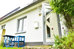 una casa con una silla azul delante de ella en Ostsee Auszeit, en Pruchten