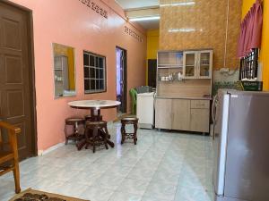 a kitchen with a table and chairs and a refrigerator at Homestay Taman Maktab Pengkalan Chepa in Pengkalan Cepa