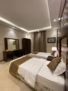 a hotel room with two beds and a mirror at فندق ترند- trend hotel in Al Baha