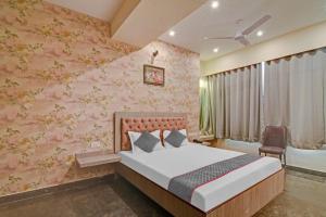 a bedroom with a bed and a pink wall at Townhouse The Den in Kolkata