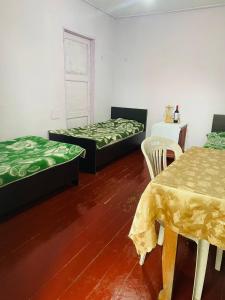a room with two beds and a table and chairs at Guesthouse ''Loni'' in Ureki
