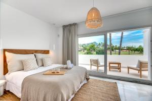 sypialnia z łóżkiem i dużym oknem w obiekcie VACATION MARBELLA I Villa Sirio, Golf-Front Villa, Private Pool, Privacy w Marbelli