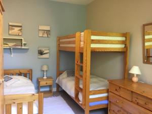 1 Schlafzimmer mit 2 Etagenbetten und einem Schreibtisch in der Unterkunft Arcachon Villa aux Abatilles in Arcachon