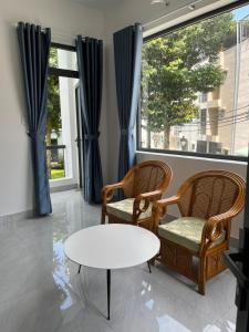 sala de estar con 2 sillas y mesa en Tropical Garden, en Ấp Long Kiên I