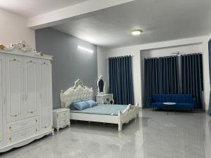 1 dormitorio con 1 cama blanca y 1 sofá azul en Tropical Garden, en Ấp Long Kiên I