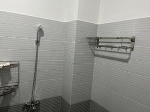 łazienka z prysznicem wyłożona białymi kafelkami. w obiekcie Tropical Garden w mieście Ấp Long Kiên I