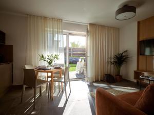 een woonkamer met een tafel en stoelen en een keuken bij Lake-Apart Apartamenty Mielno in Mielno
