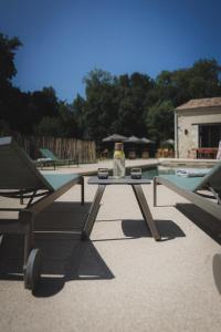 uma garrafa de álcool sentada numa mesa ao lado de uma piscina em Logis de l'Héronière em Salles-sur-Mer