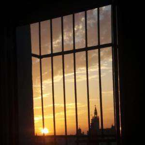 - une vue sur le coucher du soleil depuis une fenêtre avec des barres dans l'établissement Casa Mora Triana, à Séville