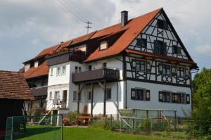 ein großes weißes Gebäude mit rotem Dach in der Unterkunft Ferienhof Hilebrand in Kressbronn am Bodensee