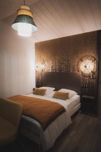 a bedroom with a large bed with two pillows at Logis de l'Héronière in Salles-sur-Mer