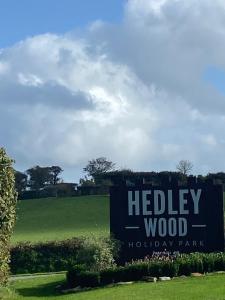 a sign for a holiday park with a field in the background at Dizzard 23 in Bridgerule