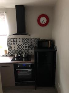 a kitchen with a stove and a clock on the wall at Just the tonic in Nottingham