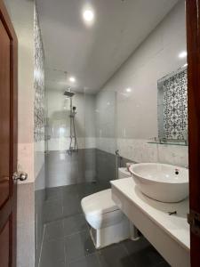 a white bathroom with a sink and a toilet at Lynk Stay Hoian in Hoi An