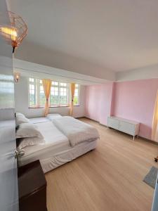 1 dormitorio con 1 cama grande y paredes rosas en The Antler Silverpark Fraser's Hill, en Bukit Fraser