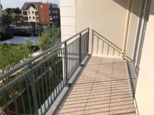 - un balcon dans un immeuble avec une balustrade dans l'établissement BEAU STUDIO NEUF AVEC TERRASSE, au Blanc-Mesnil