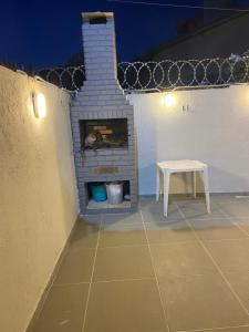 a patio with a brick fireplace and a table at Vilage beira-mar Itacimirim in Camaçari