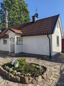 una pequeña casa blanca con un lecho de flores delante de ella en Casa Bianca, en Vadstena