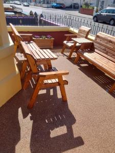 a row of wooden benches sitting next to a building at Bianca Guesthouse in Blackpool