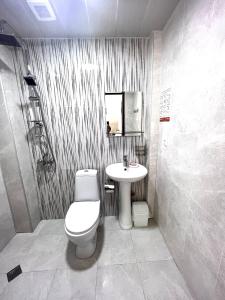 La salle de bains est pourvue de toilettes et d'un lavabo. dans l'établissement Rio cottage apartment, à Ureki