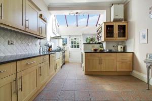 a large kitchen with wooden cabinets and a large window at A Hidden Gem in Burnham