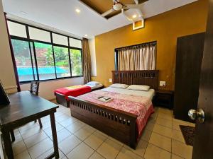 a bedroom with a bed and a table and a pool at Suman Cottage & Bungalow in Mahabaleshwar
