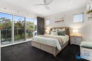 a bedroom with a bed and a large window at Tuart Heights in San Remo in Mandurah