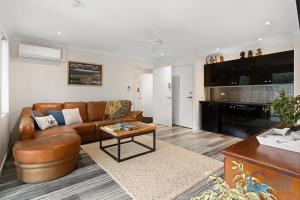 a living room with a couch and a table at Tuart Heights in San Remo in Mandurah