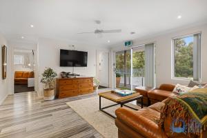 a living room with a couch and a tv at Tuart Heights in San Remo in Mandurah