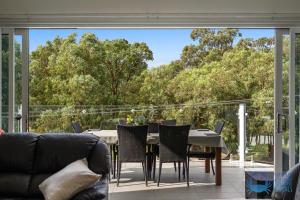 a living room with a table and chairs on a balcony at Tuart Heights in San Remo in Mandurah