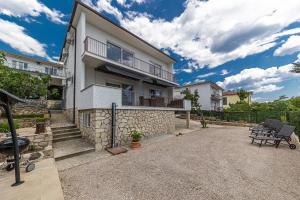 a house with a stone fence and a patio at Holiday Home Ninna in Crikvenica