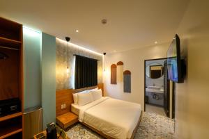 um quarto com uma cama e uma televisão de ecrã plano em J Boutique Hotel El Nido em El Nido