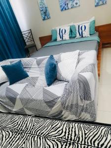 a bed with white and blue pillows on it at Studio 5B with Balcony across Terminal 3 Airport in Manila