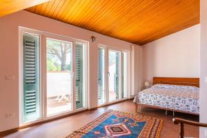 a bedroom with a bed and large windows at Quercianella Lovely Villa near the Sea W/Parking! in Quercianella