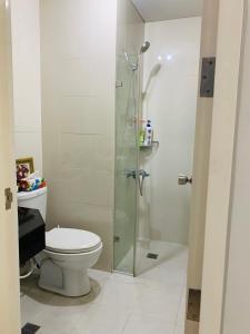 a bathroom with a toilet and a glass shower at Studio 5B with Balcony across Terminal 3 Airport in Manila