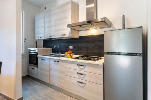 a kitchen with a stainless steel refrigerator and a stove at Quercianella Lovely Villa near the Sea W/Parking! in Quercianella