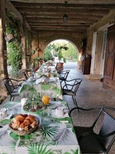 Hay una mesa larga para comer en una sala al aire libre. en LA SEIGNEURIE DE TILLAC, en Tillac