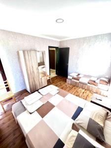a bedroom with two beds and a checkered floor at Rio cottage apartment in Ureki
