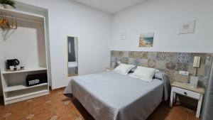 a bedroom with a bed with two pillows on it at Hostal Canalejas in Cádiz