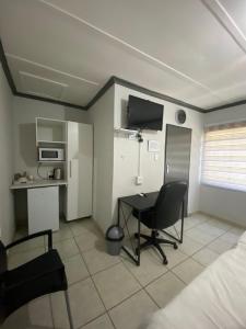a room with a bedroom with a desk and a bed at liam travel inn in Nelspruit