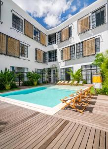 Una vista exterior de un edificio con piscina. en Tropicana Loft Canggu, en Canggu